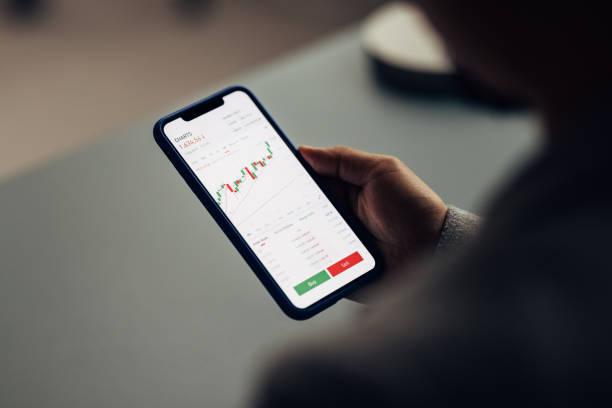 istock Person Checking Stock Market Graphs on Smartphone in a Casual Setting 2040237493