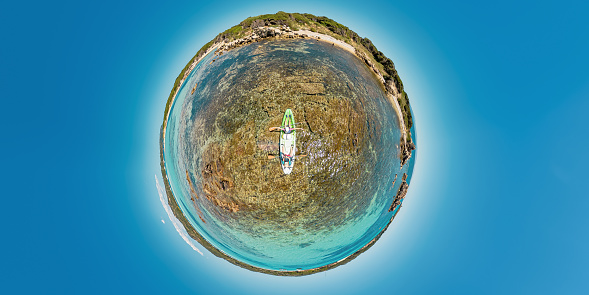 Tiny planet 360 view of kayak from Piantarella beach. Aerial view of Piana island in Corsica of France. People kayaking in Mediterranean by Piana island and Petit Sperone beach Concept of environment