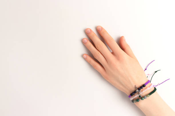 Female hand with a macrame bracelets on it on a gray baclground.