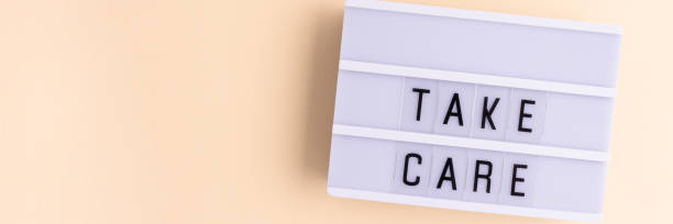 istock Take care. Banner with white lightbox with letters on a beige background. 2040242453