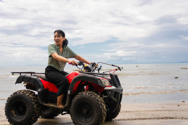 istock asian Woman on a quad on the beach 2040253343
