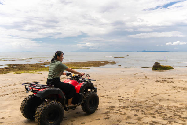 istock asian Woman on a quad on the beach 2040253852