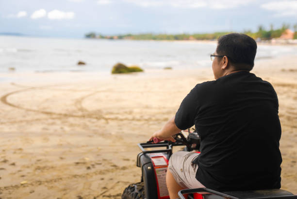 Asian man on a quad on the beach