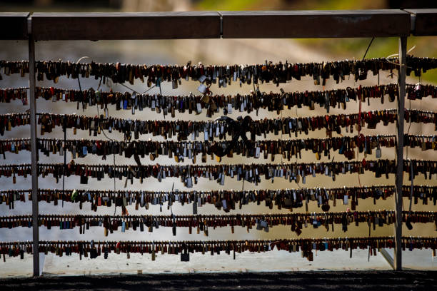 Padlocks Hanging on Bridge Fence Over a River.