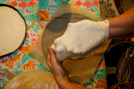 Woman Stretching Pizza Dough at Home.