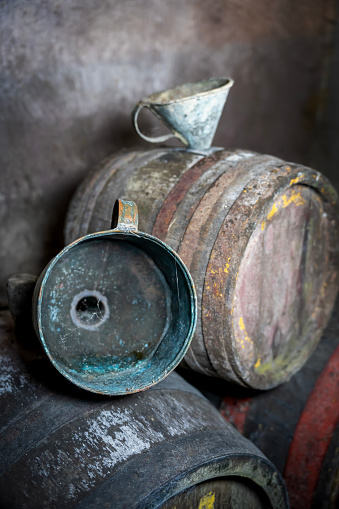 Old vintage wine barrels, an old metal watering can
