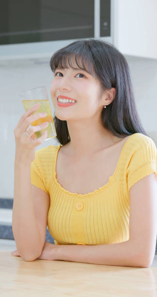 Closeup asian woman happily drinks iced drink feeling comfortable and pleasure - she has health teeth