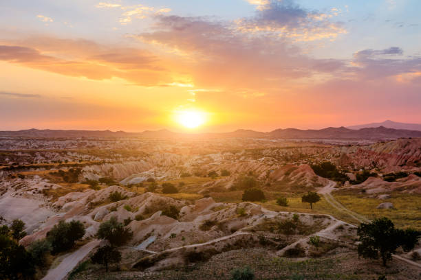 Cappadocia sunset with vibrant colors, captures the final beams of sunlight, casting luminous glow upon the extraordinary scenery beneath of Kayasehir Rocktown of Goreme rocktown in Turkey.