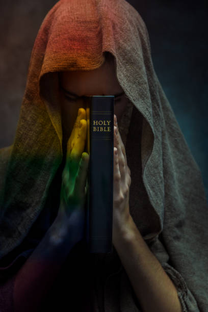 Monk painted to rainbow praying in dark room