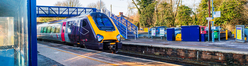 February 26th. 2024. A view of Widney Manor Solihull West Midlands England UK. Diesel powered railway line in the English countryside. Station on a bright day in late summer. There are no visible people in the picture. Express train speeding through station.