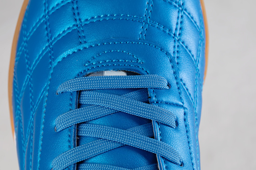 Part of a blue leather lace-up sneaker close-up. Shoe leather close-up.