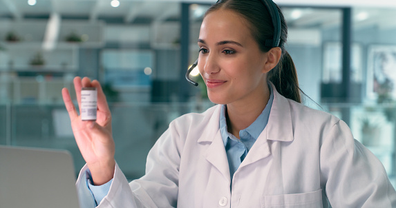 Doctor, video call and a healthcare woman consulting a client online with a bottle of pills for treatment. Telehealth, medical and remote appointment with a health professional talking for diagnosis