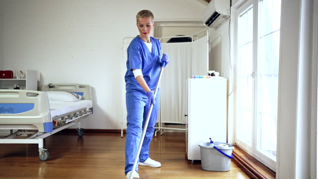 Woman mopping floor at the hospital ward
