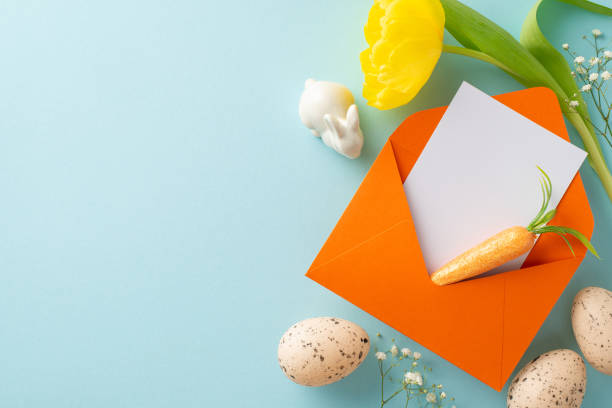 istock Anticipating Easter, a neatly arranged top view display of a letter for the Easter bunny, eggs, carrot, gypsophila flowers, and tulip set against a pastel blue background, with space for text or ads 2040342054