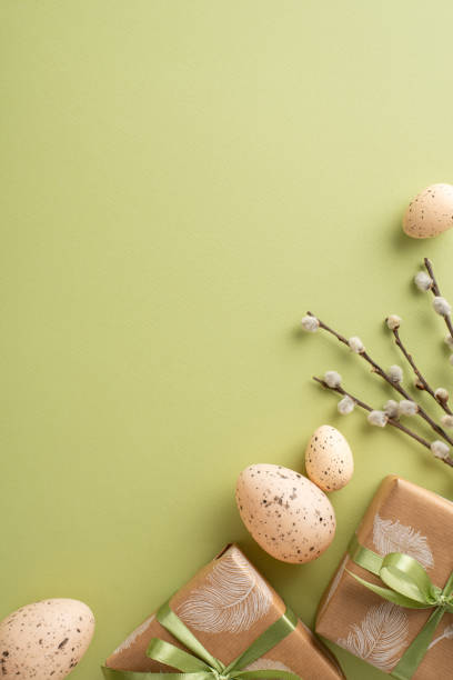 istock Whimsical Easter composition idea. Vertical top view of crafty gift boxes, quail eggs, natural pussy willow, spread on a soft green background with space left for text or ads 2040342088