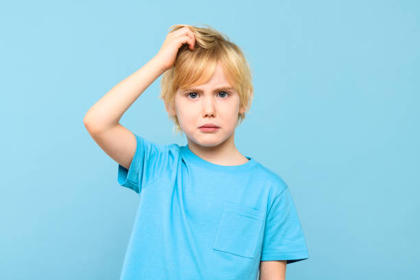 istock Young doubtful confused boy thinking, scratching head, trying to find solution, isolated on pastel blue background. 2040344758