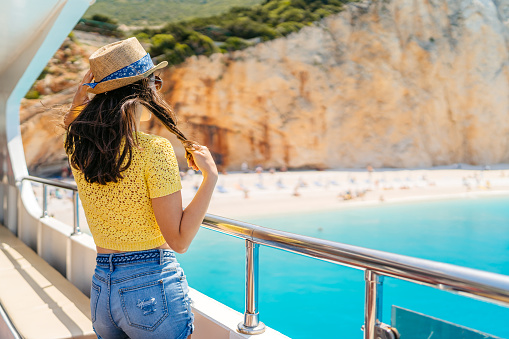 Young woman looking at view of the Porto katsiki beach from the boat in Parga in Greece.