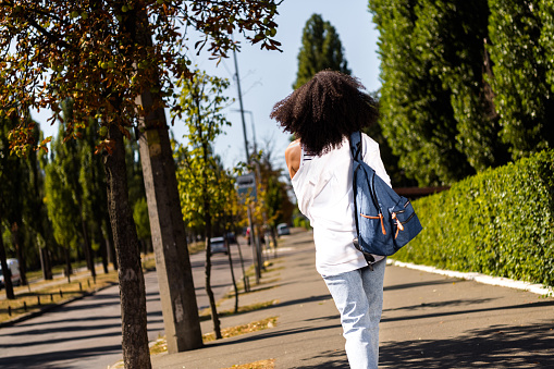 Photo of lovely adorable girl dressed white trendy outfit carrying rucksack going home summer outside.