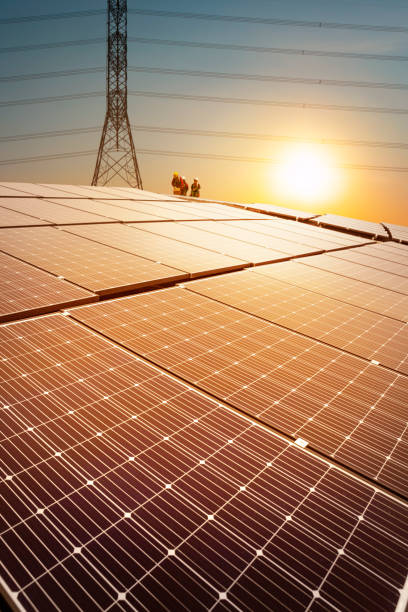 istock Installing solar panels, and high-voltage electricity transmission pylons in behind. Clean energy and the environmentally friendly. 2040358072