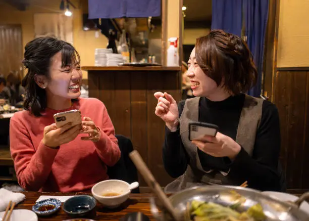 Female friends eating “motsunabe” Japanese food for dinner