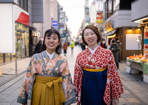 Portrait of female friends in Kimono / Hakama walking on in traditional Japanese town