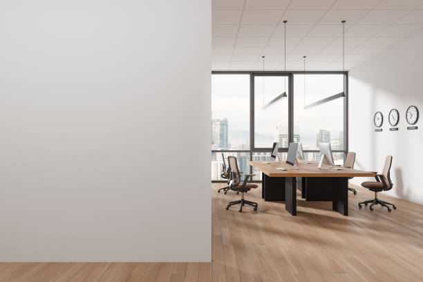 istock Cozy coworking interior with pc desktop, world clock and window. Mock up wall 2040368255