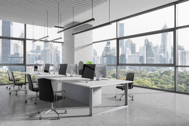 istock Office workplace interior with desk and pc monitors in row, panoramic window 2040370404