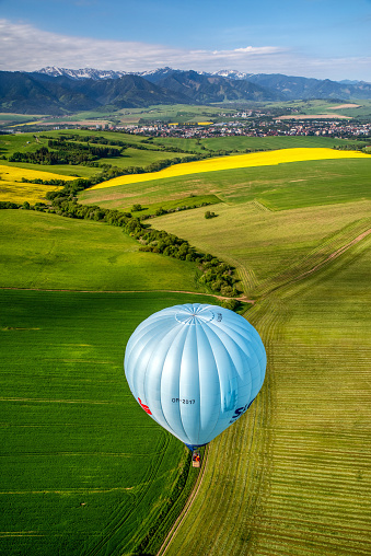 Liptovsky Mikulas, Slovakia - Jun 2, 2021: Blue hot-air balloon and beautiful green fields in Liptov area