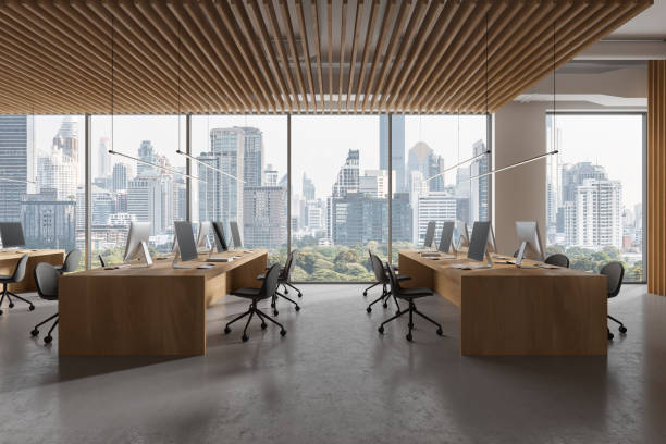 istock Stylish office interior with chairs, pc computers and table in row near window 2040394151