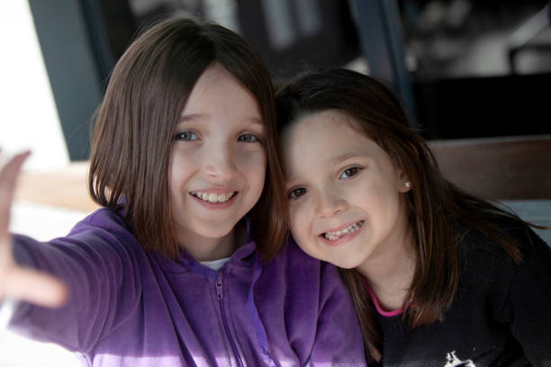 Two nice and cute sister portrait at home the little child look et camera