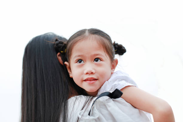 Close up mother carrying her daughter on white background.