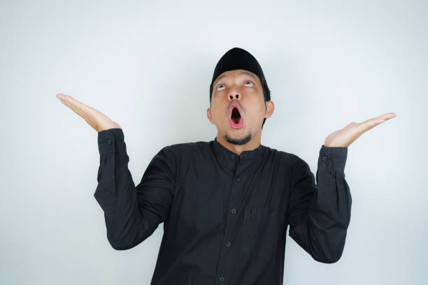 istock Wow face shocked expression Asian Muslim man pointing hand finger at empty space on isolated background 2040413543