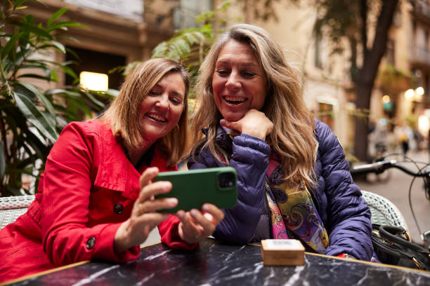 istock Joyful Moment: Two Women Share Phone Screen with Happiness 2040417798