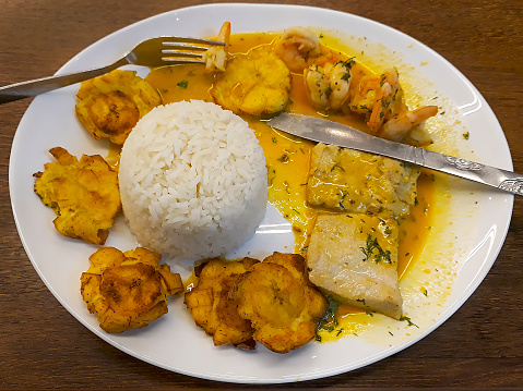 Top view shot fish with patacones and white rice at white dish traditional ecuadorian food