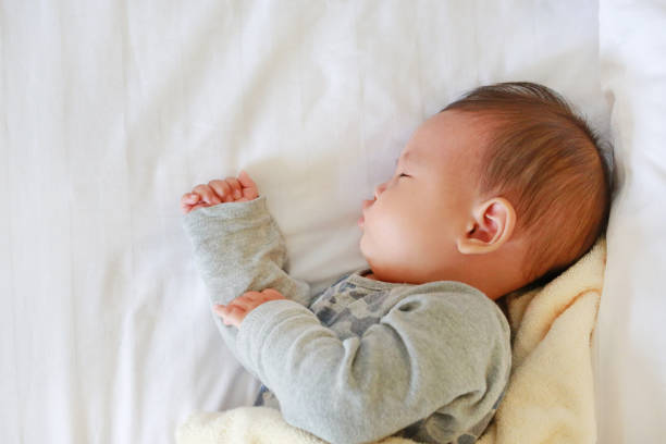 istock Close up infant baby boy sleeping on bed with the blanket. 2040439873