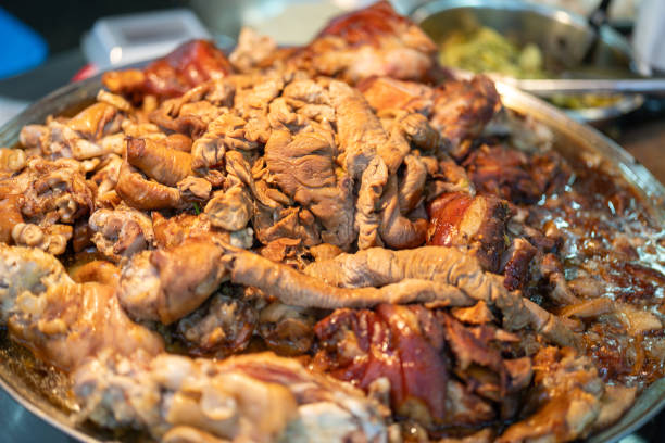 Close-up at part of pork meat and entrails that are stewed on the boiling pot to cooking as the pork leg menu. Thai street food menu, selective focus.