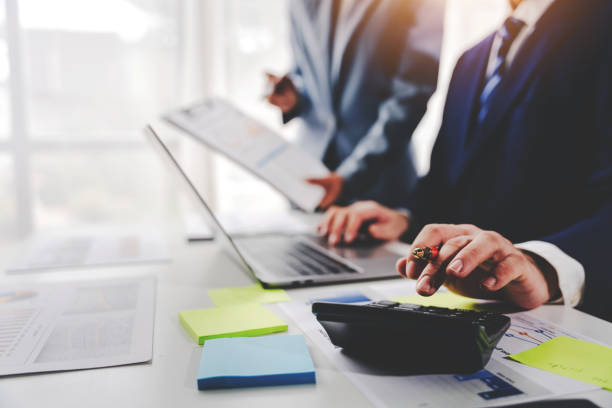 istock Colleagues discuss business charts and analytical prices using calculators and laptops to calculate finance, taxes, accounting, statistics, teamwork concept. Calculate personal taxes for clients 2040461759