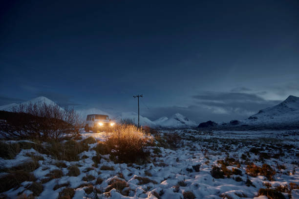 istock 4x4 car with lights on in with snow covered landscape. 2040468714