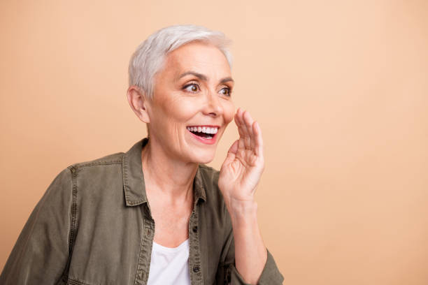 istock Portrait of beautiful lady chatterbox saying secrets touch cheek looking empty space announcement speech isolated on beige color background 2040474708