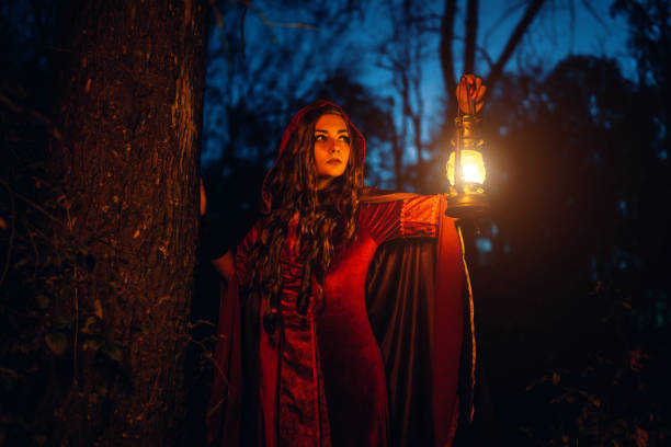 istock Witch Holding A Lantern In The Forest At Night 2040481262