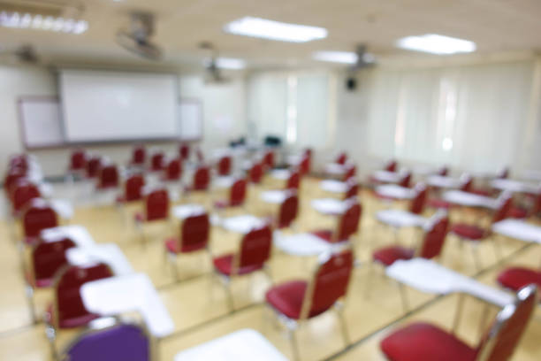 istock Blurred abstract background of examination room with undergraduate students inside. Blurred view of a student doing the final test in the exam room. Blurry view of study chairs in university. 2040514669