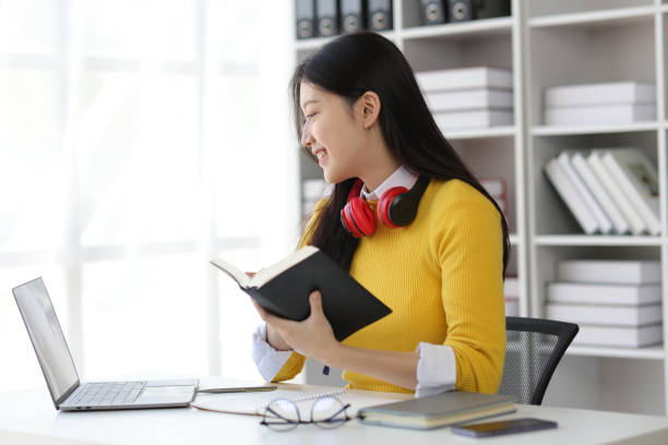 istock Beautiful Asian female student reading academic books in university library. 2040531589