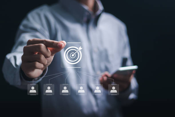 istock Customer relationship management concept. Businessman holding target icon linked with human icons for customer focus group. Data exchanges development and customer service. 2040543069