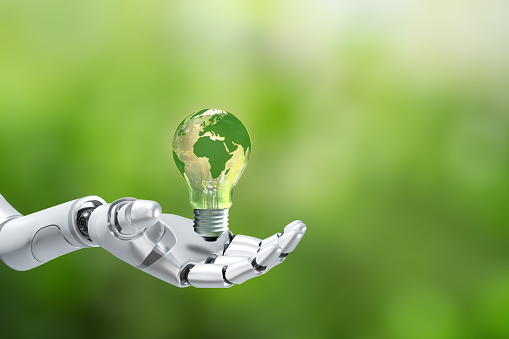 Robot hand holding light bulb with green world map on green background.Renewable Energy.Environmental protection, renewable, sustainable energy sources.Artificial Intelligence and Technology Ecology.