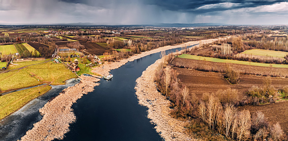 A serene river landscape framed by lush pastures, ideal for adventures and birdwatching.