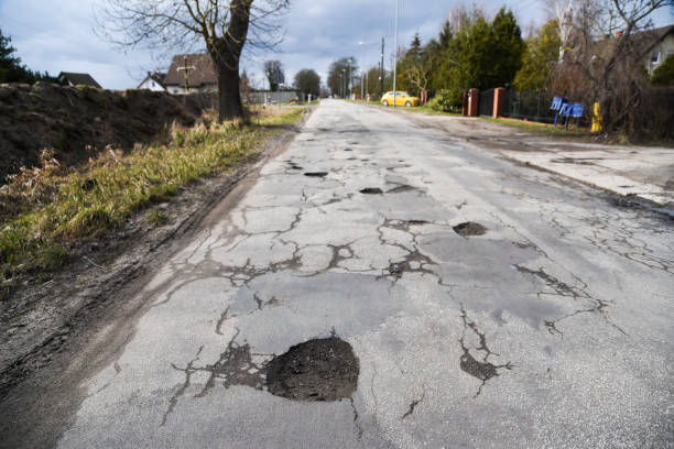 istock Hole in the road on a damaged asphalt surface. 2040581275
