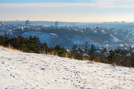 Outlook from snowy meadow in hillside to rock quarter Branik in Prague, Czech republic. Winter sunny day.