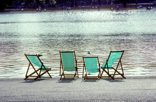 four empty deck chairs at the Hyde Park in London, UK