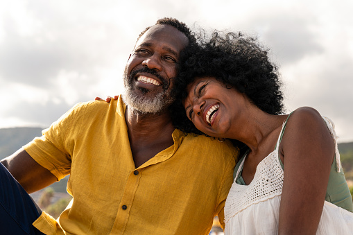 Beautiful mature black couple of lovers dating at the seaside - Married african middle-aged couple bonding and having fun outdoors, concepts about relationship, lifestyle and quality of life