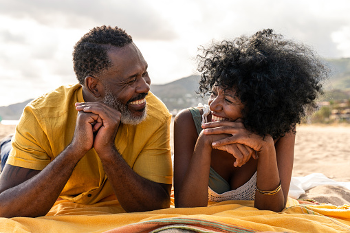 Beautiful mature black couple of lovers dating at the seaside - Married african middle-aged couple bonding and having fun outdoors, concepts about relationship, lifestyle and quality of life
